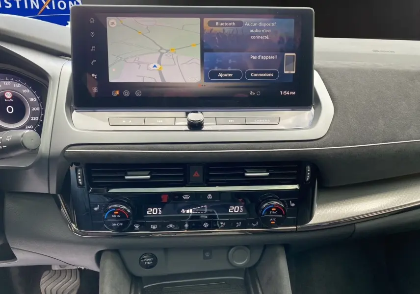 Tableau de bord du Nissan Qashqai 2025 en vue frontale, avec écran tactile et commandes climatisation digitales.