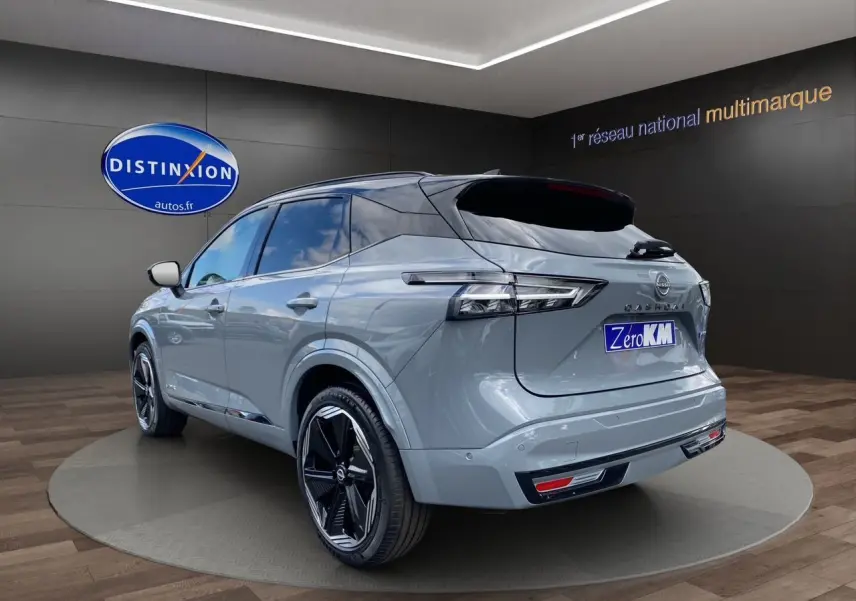 Vue 3/4 arrière droite du Nissan Qashqai 2025 gris ceramic et noir avec jantes noires distinctives en showroom