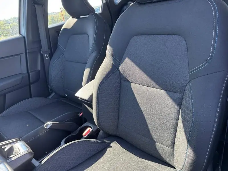 Vue rapprochée des sièges avant noirs du Renault Captur 1.0 TCe 90ch Evolution 2025, soulignant les détails de la sellerie.