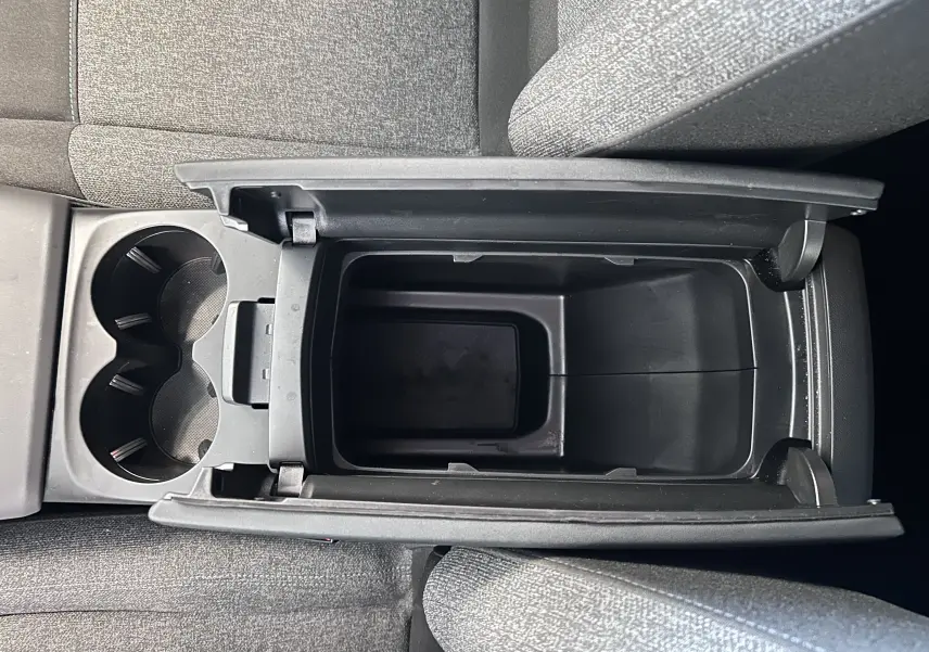 Vue plongeante sur le rangement central ouvert et porte-gobelets du Citroën C5 Aircross 2024 en tissu gris.