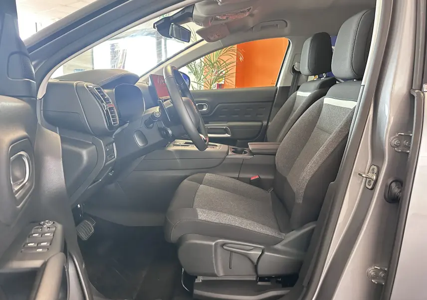 Vue intérieure côté conducteur du Citroën C5 Aircross gris Artense 2024, sièges tissu bicolore et volant cuir.