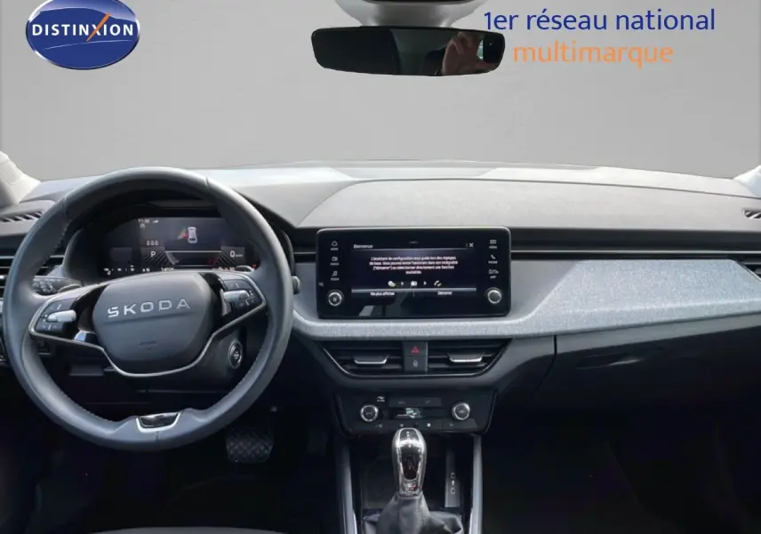 Vue intérieure frontale du tableau de bord gris noir et volant cuir multifonction de la Skoda Scala 2025 blanc glacier.