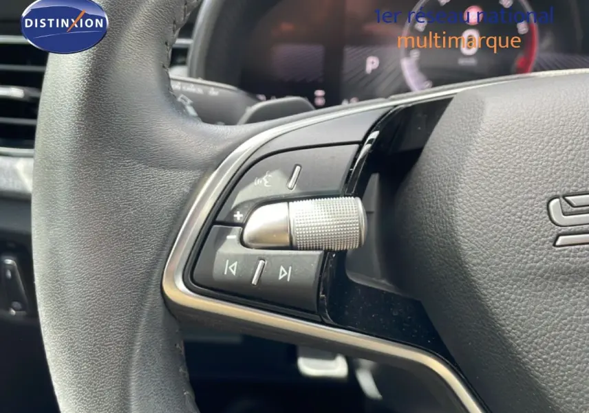 Gros plan sur la partie gauche du volant gris noir du Skoda Scala 2025 avec commandes audio et régulateur.