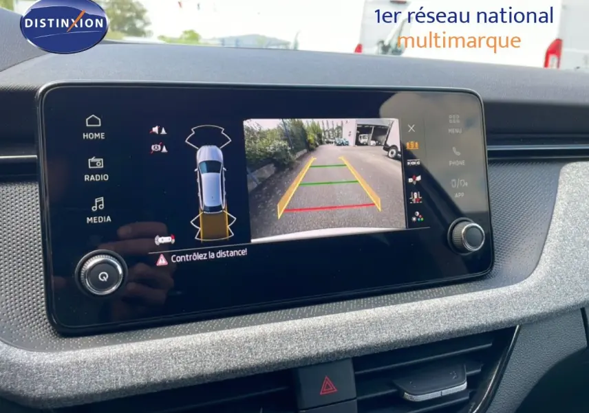 Écran central affichant la caméra de recul et les capteurs de distance d'une Skoda Scala blanc glacier, vue intérieure.