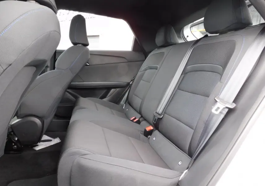 Vue latérale droite de l'habitacle arrière du MG4 2023 avec sièges tissu gris et ceintures de sécurité visibles.