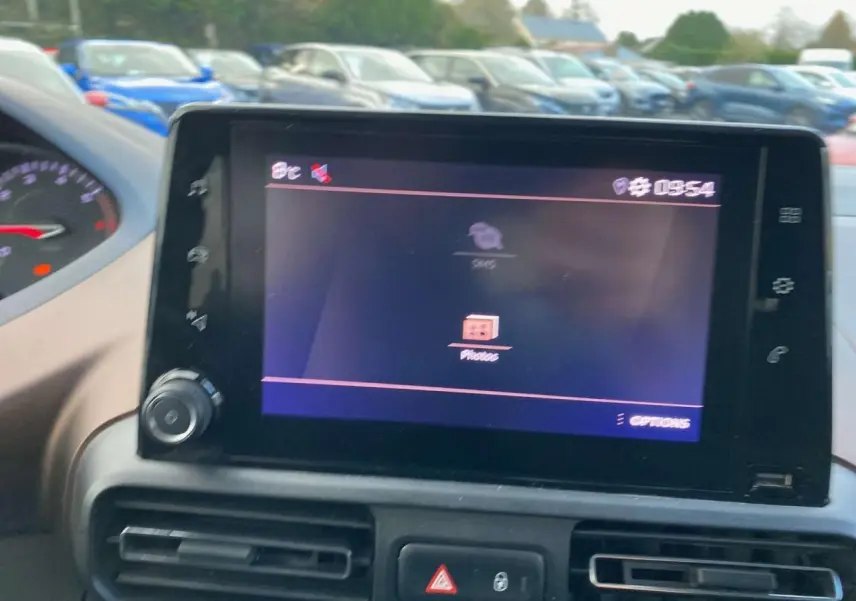 Écran tactile central de la Peugeot Rifter GT 2023, vue intérieure du tableau de bord avec commandes visibles.