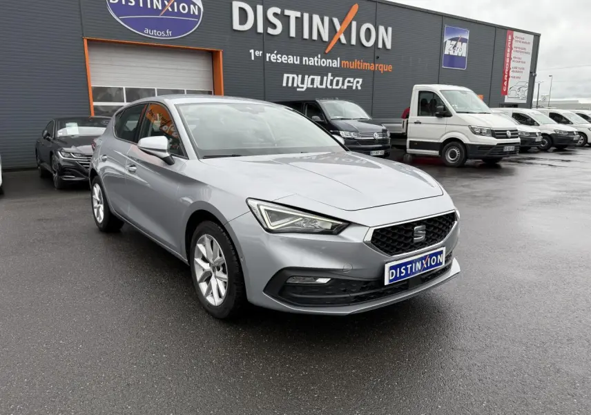 SEAT Leon 2.0 TDI 2022 argent Urban vue 3/4 avant sur parking devant concession multimarque