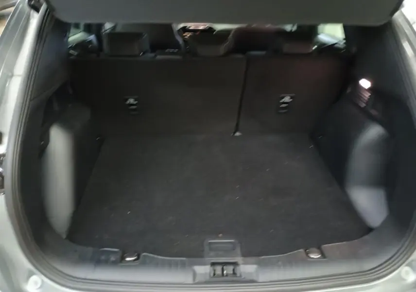 Coffre ouvert du Ford Kuga gris Solar 2024, vue intérieure arrière montrant l'espace de chargement vide.