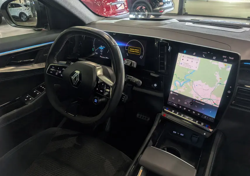 Vue intérieure côté conducteur du Renault Austral E-Tech hybrid 200 Iconic esprit Alpine, avec tableau de bord numérique et écran tactile central.