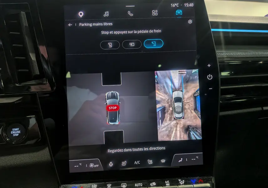 Écran central du Renault Austral E-Tech hybrid 200 Iconic esprit Alpine montrant l’aide au stationnement avec vue aérienne du véhicule.