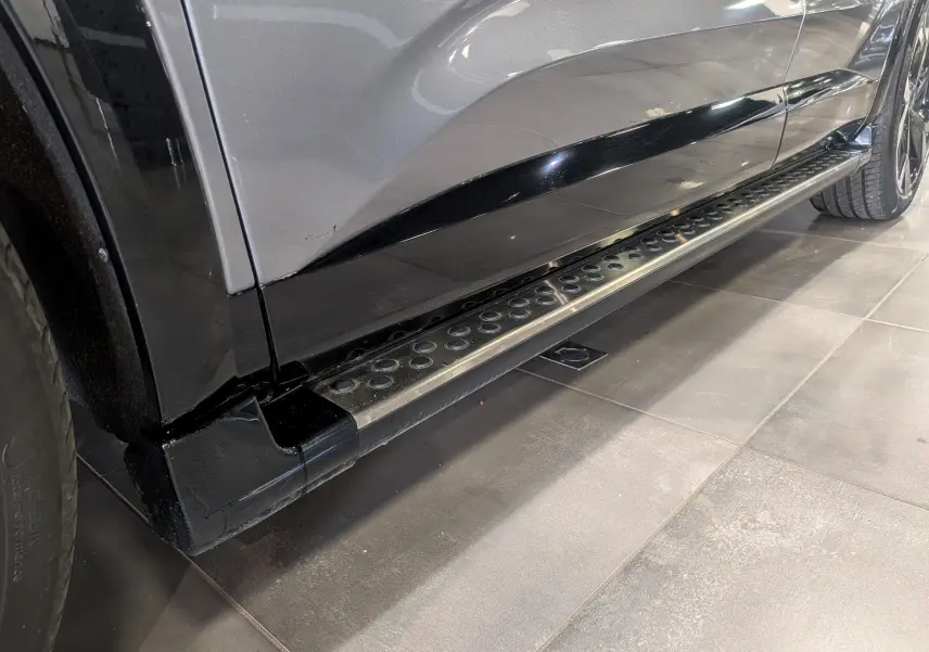 Gros plan sur la marche latérale côté gauche du Renault Austral E-Tech hybrid 200 Iconic gris schiste avec toit noir.