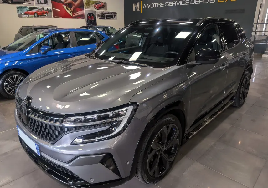 Renault Austral E-Tech hybrid 200 Iconic esprit Alpine gris schiste avec toit noir, vue 3/4 avant droit en showroom.