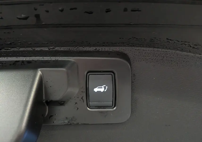 Bouton intérieur noir avec symbole blanc d'ouverture du coffre, sur Renault Austral E-Tech hybrid 2023.