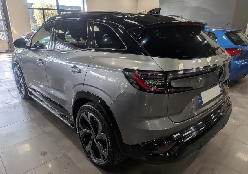 Vue 3/4 arrière droite du Renault Austral E-Tech hybrid 200 Iconic esprit Alpine en gris schiste avec toit noir brillant.