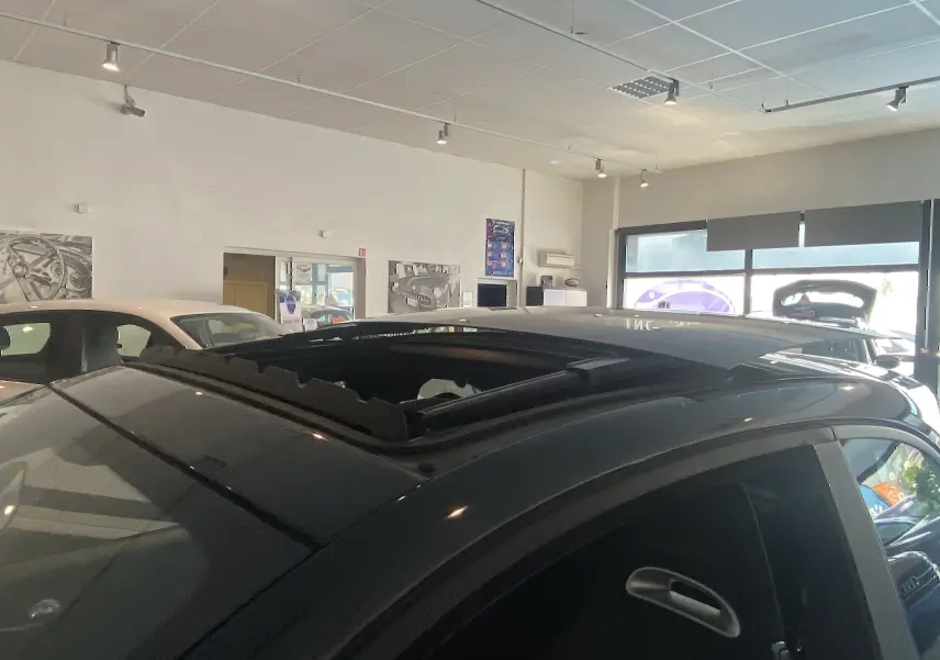 Vue rapprochée du toit ouvrant électrique noir d'une ABARTH 595 2018 en showroom lumineux.