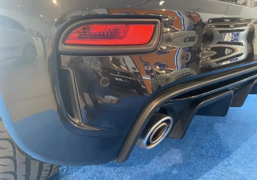 Gros plan sur le feu arrière droit et la sortie d'échappement d'une ABARTH 595 noire, finition brillante.