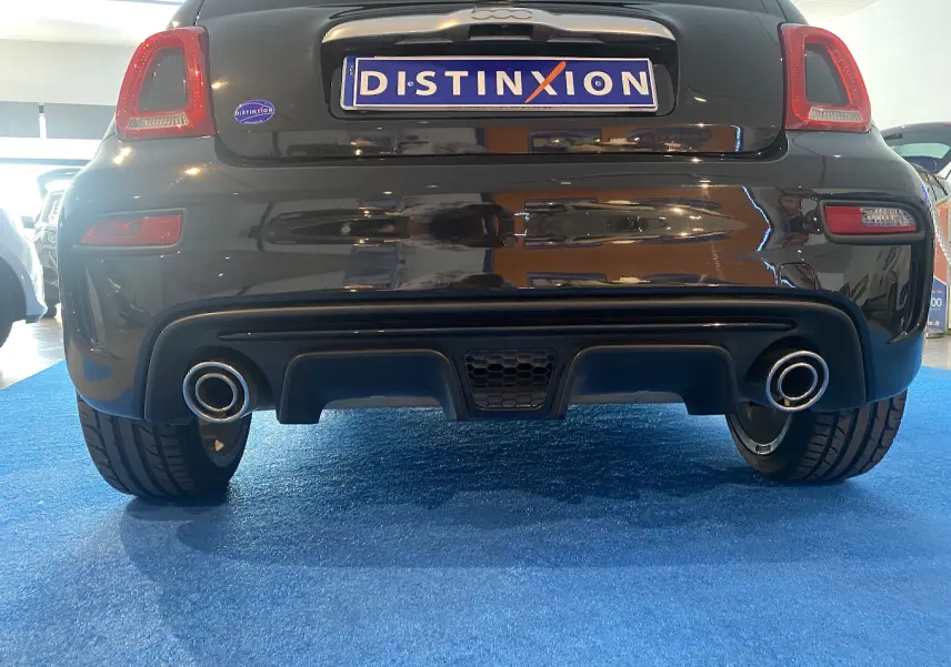 Vue arrière basse d'une ABARTH 595 noire avec double sortie d'échappement et logo Distinxion sur plaque arrière.