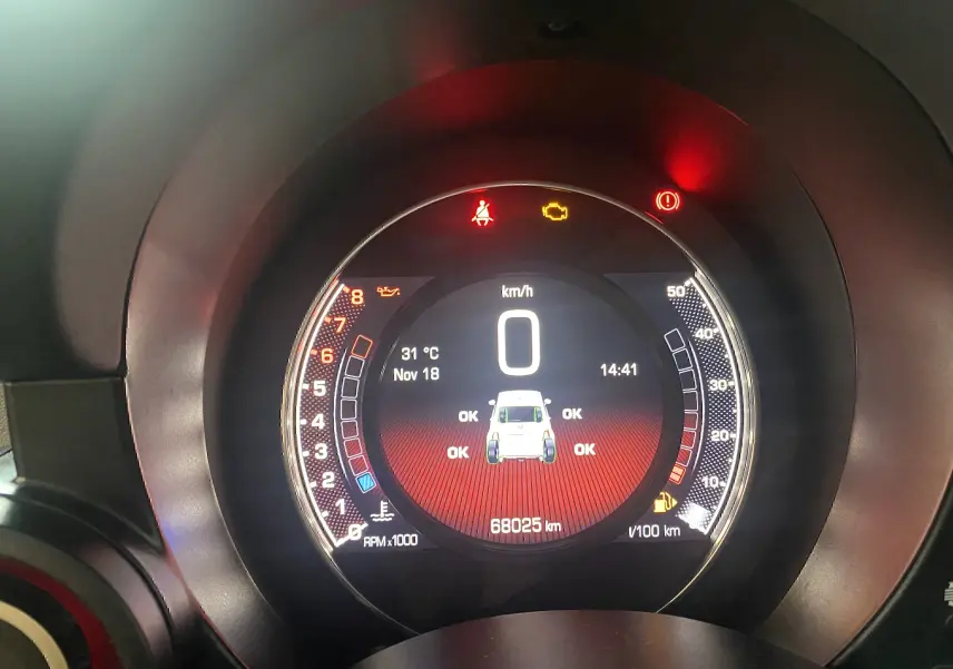 Vue rapprochée du tableau de bord numérique de l'Abarth 595 noir, affichant la vitesse à 0 km/h et les alertes au rouge.