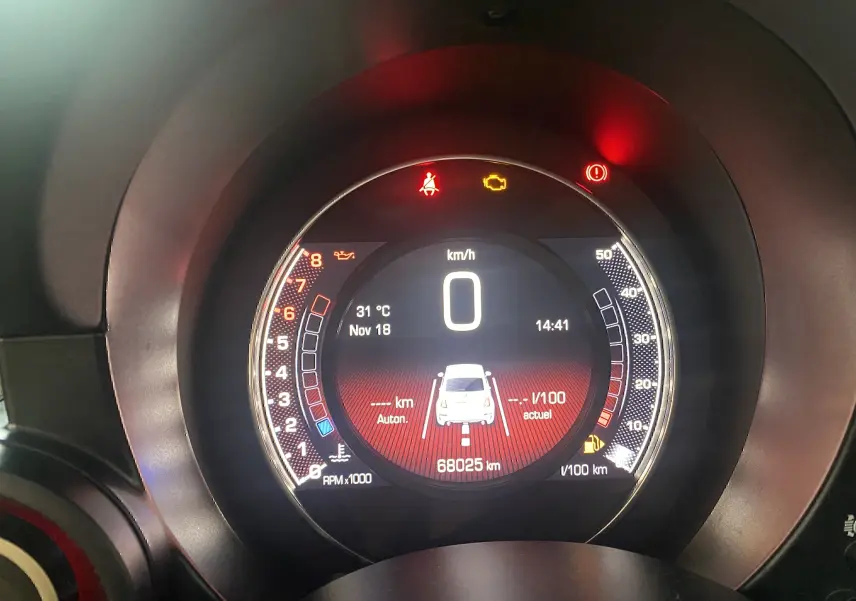 Tableau de bord numérique de l'Abarth 595 noir, affichant vitesse à 0 km/h et témoins lumineux allumés.