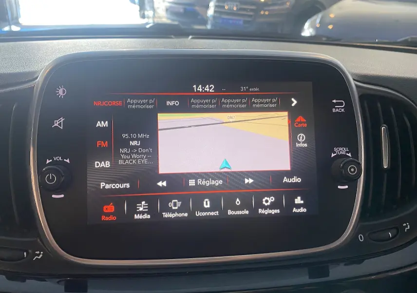 Écran tactile GPS allumé au centre du tableau de bord noir d'une ABARTH 595, avec commandes autour visibles.