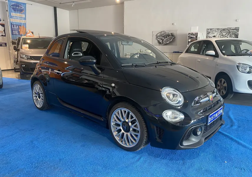 ABARTH 595 noir en 3/4 avant droit dans un showroom, avec jantes alu et toit ouvrant électrique visible.