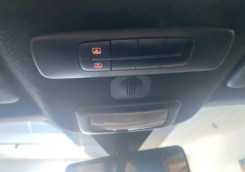 Vue intérieure du toit ouvrant électrique et des commandes de toit de l'Abarth 595 noire de 2018.