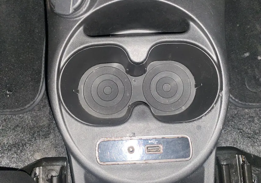 Gros plan sur les porte-gobelets et prise USB au centre de la console d'une ABARTH 595 noire de 2018.