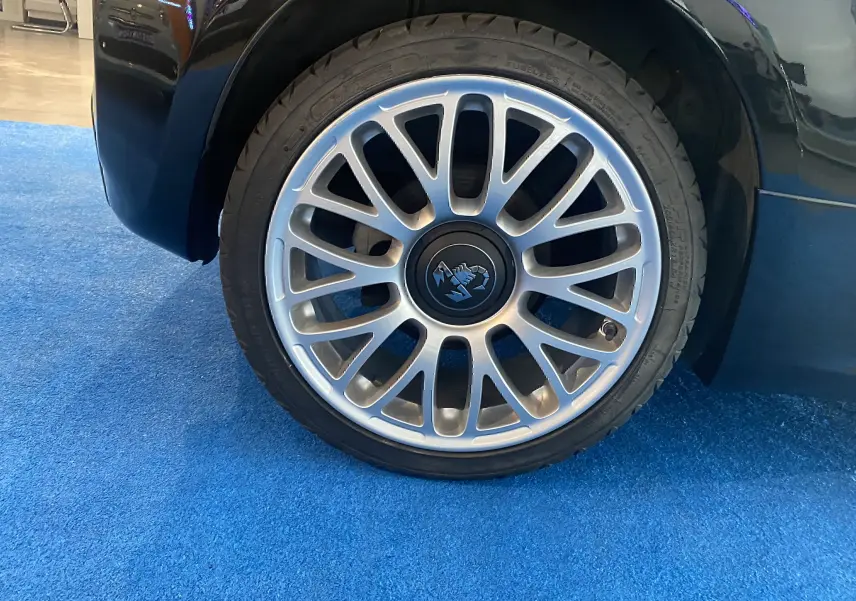 Gros plan sur la jante alu argentée avec logo Abarth au centre, côté arrière droit d'une ABARTH 595 noire.