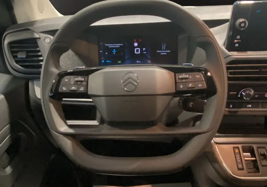 Volant et tableau de bord du Citroën Jumpy Fourgon gris, avec écran numérique et commandes intégrées au volant.