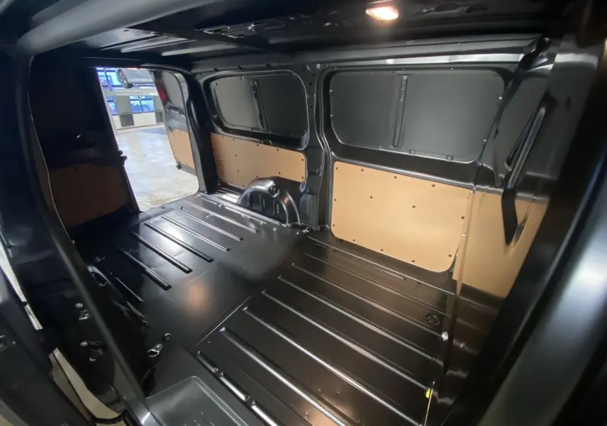 Intérieur du fourgon Citroën Jumpy gris platinium, vue de l'espace de chargement avec parois tôlées et plancher métallique.