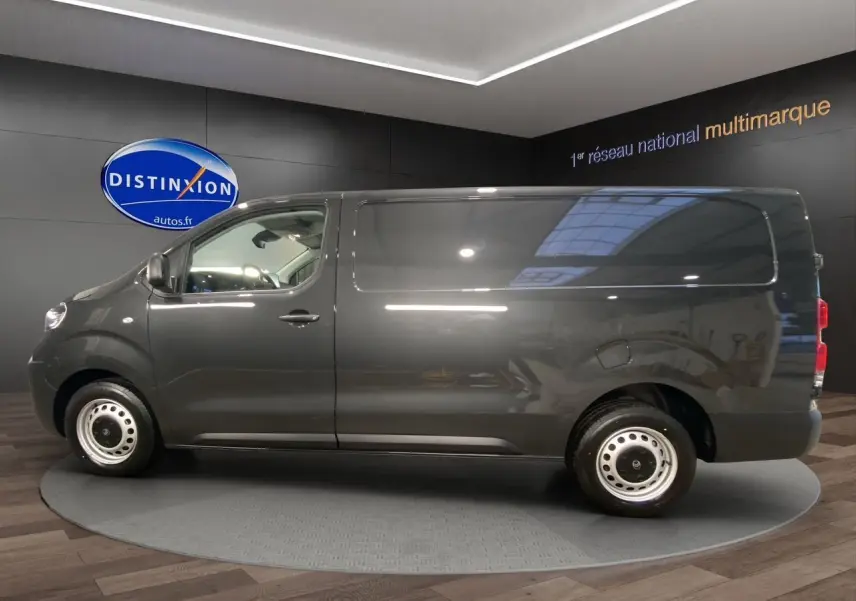 Vue latérale droite d'un Citroën Jumpy Fourgon gris platinium, sans fenêtres latérales arrière, en showroom.
