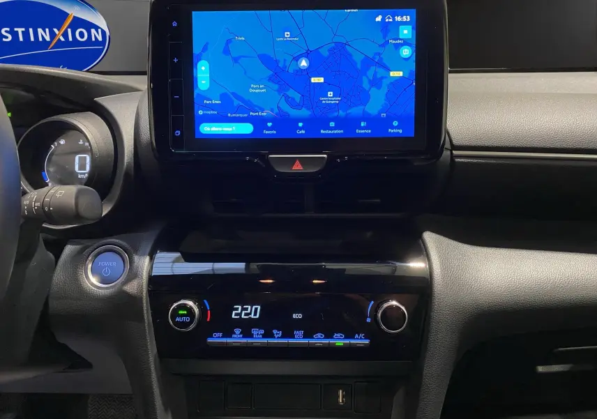 Vue rapprochée du tableau de bord noir de la Toyota Yaris Cross 116H avec écran tactile affichant la navigation.