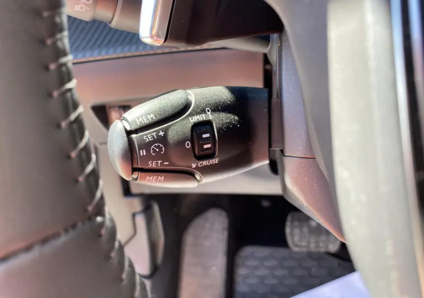Gros plan sur la commande de régulateur de vitesse du Peugeot 2008 2021, côté gauche du volant en cuir noir.