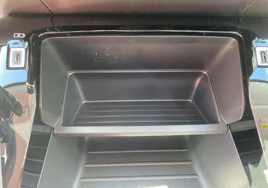 Gros plan sur la console centrale noire du Peugeot 2008 2021, avec prises USB et finition brillante autour.