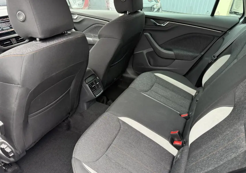 Vue intérieure arrière côté droit du Skoda Kamiq 2022, sièges tissu gris avec inserts clairs et appuie-tête.