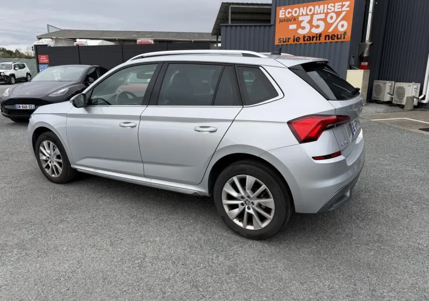 Vue 3/4 arrière droite d'un Skoda Kamiq gris métallisé garé sur un parking avec jantes alliage 17 pouces.