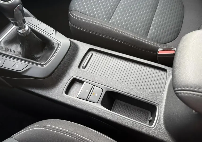 Gros plan sur la console centrale et levier de vitesses manuelle du Ford Kuga 2024, intérieur gris avec surpiqûres blanches.