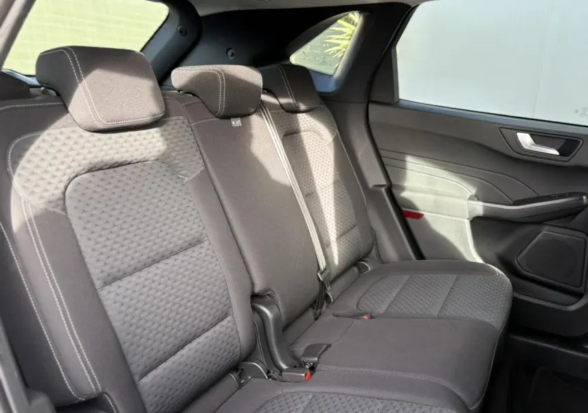 Vue latérale droite des sièges arrière gris foncé du Ford Kuga 2024, montrant les appuie-têtes et la portière intérieure.