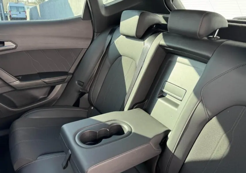 Vue intérieure côté droit sur la banquette arrière noire du CUPRA Formentor avec accoudoir central et porte-gobelets.