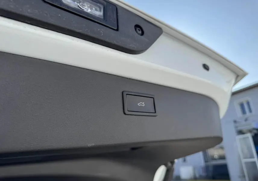 Bouton d'ouverture électrique du coffre sur la partie intérieure du hayon d'un CUPRA Formentor blanc nacré.