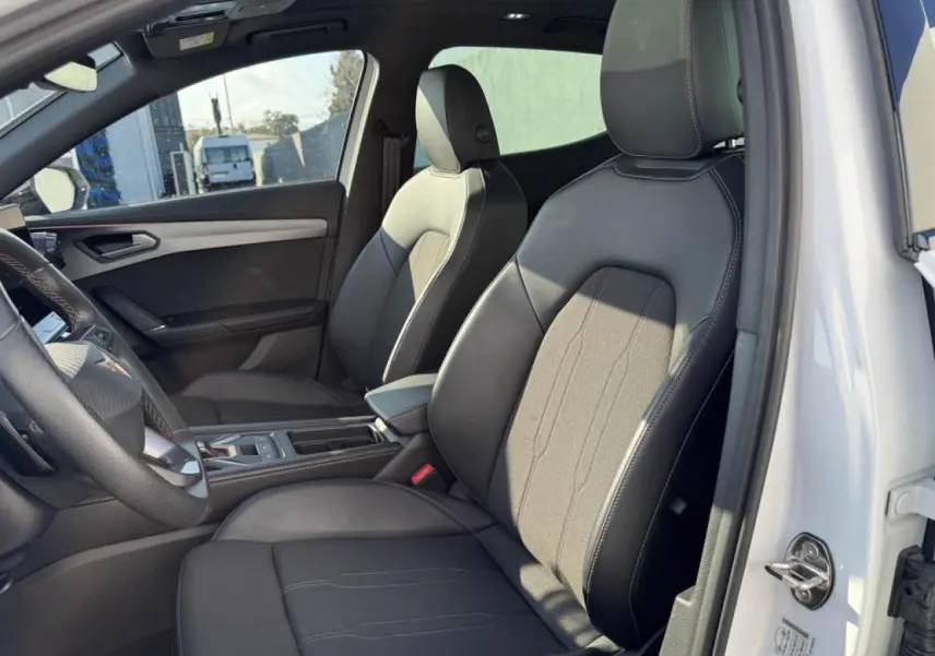 Vue intérieure côté conducteur du CUPRA Formentor blanc nacré, sièges sport noirs avec surpiqûres contrastées.