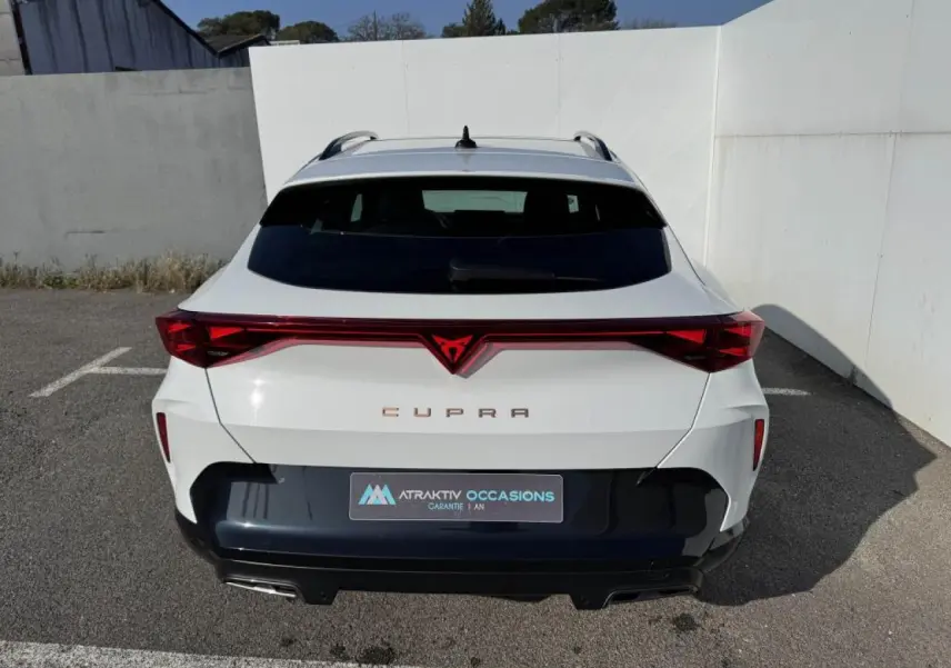 Vue arrière d'un CUPRA Formentor blanc nacré avec toit noir et bandeau lumineux rouge intégrant le logo CUPRA.