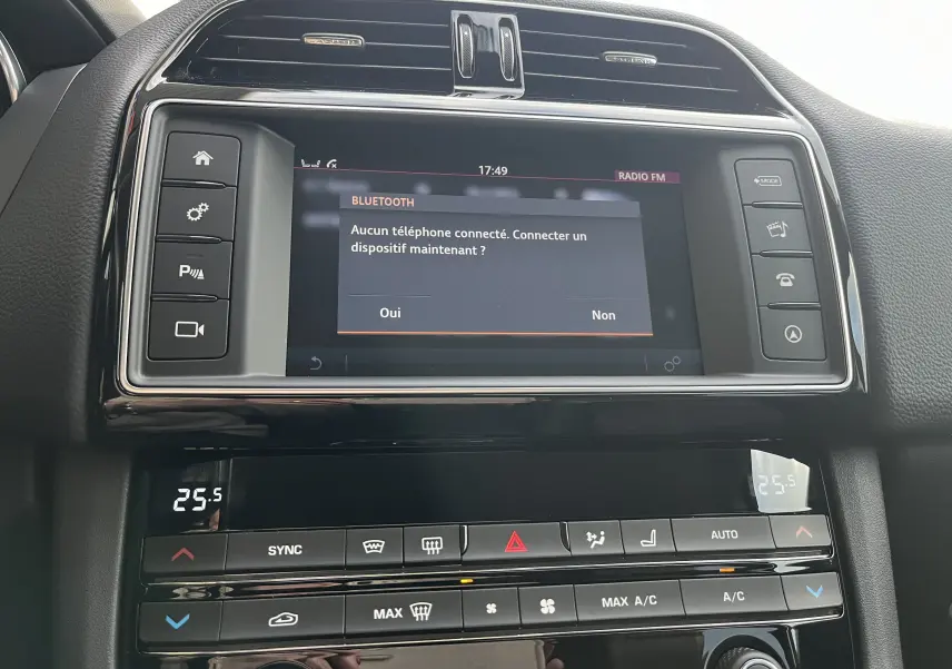 Vue rapprochée de la console centrale du Jaguar F-PACE blanc 2018, écran tactile affichant la connexion Bluetooth.