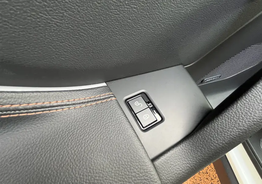 Détail intérieur côté conducteur du Jaguar F-PACE blanc 2018, montrant les boutons de verrouillage sur la porte en cuir noir.