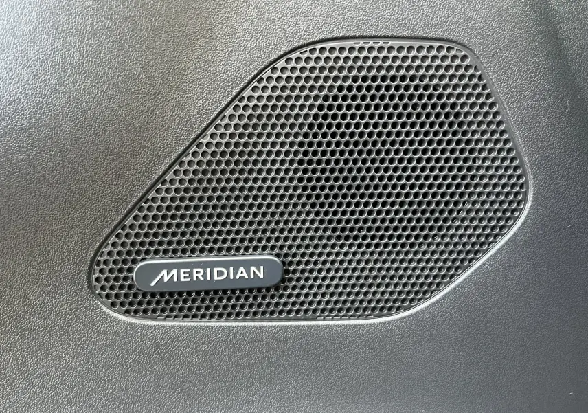 Gros plan sur le haut-parleur Meridian intégré à la porte intérieure du Jaguar F-PACE 240D Prestige blanc de 2018.