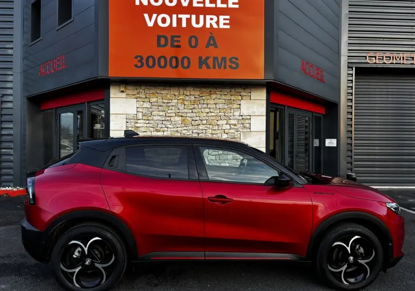 Vue latérale droite d'une Alfa Romeo Junior 1.2 Ibrida rouge 2024, avec toit noir et jantes distinctives noires et argentées.