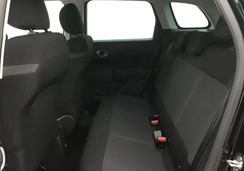 Vue intérieure côté droit de la banquette arrière noire du Citroën C3 Aircross 2024 avec appuie-têtes et ceintures visibles.