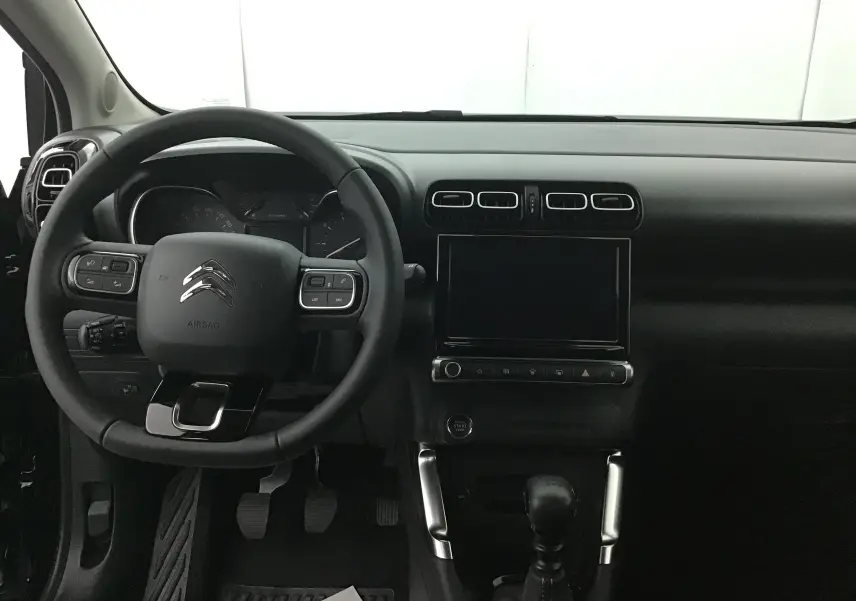 Intérieur noir du Citroën C3 Aircross 2024, vue frontale sur le volant multifonction et la console centrale tactile.