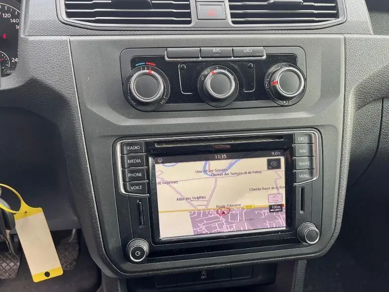 Tableau de bord noir du Volkswagen Caddy Van blanc 2016 avec écran tactile GPS et commandes de climatisation.