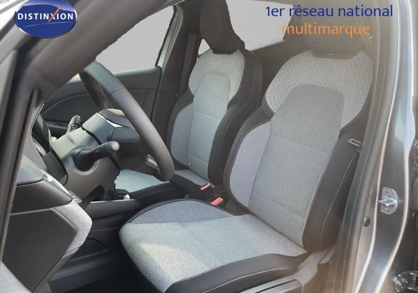 Intérieur de la Renault Clio 1.5 DCI 100ch Evolution 2025, sièges tissu gris clair et noir vus côté conducteur avec volant visible.